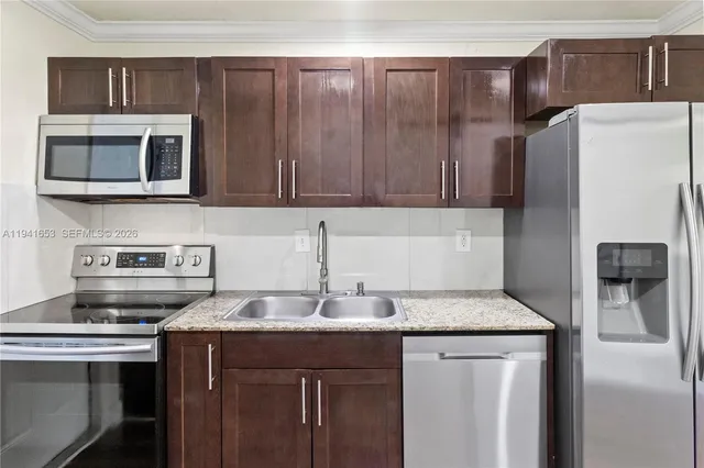 a kitchen with stainless steel appliances granite countertop a sink stove and refrigerator