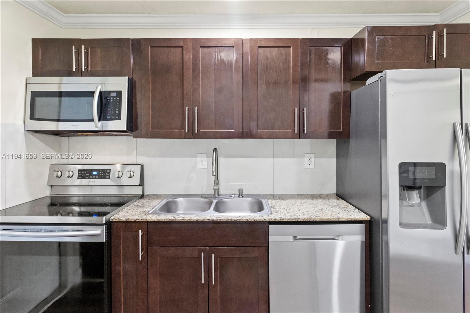 441 Northeast 30th Street, Unit 12 Pompano Beach, FL 33064 - Photo 16 of 33 a kitchen with stainless steel appliances granite countertop a sink stove and refrigerator