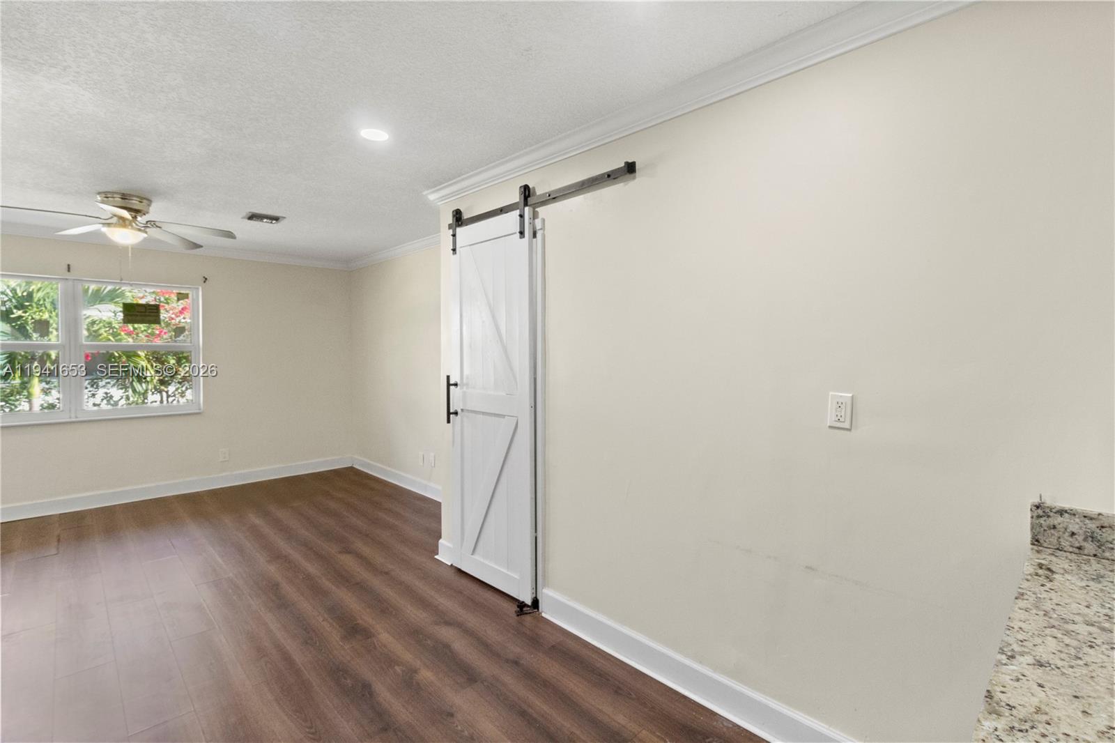 441 Northeast 30th Street, Unit 12 Pompano Beach, FL 33064 - Photo 25 of 33 a view of an empty room with a window and wooden floor