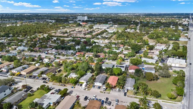 an aerial view of residential houses with outdoor space and trees