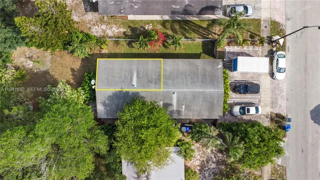 an aerial view of a house with a yard and large trees