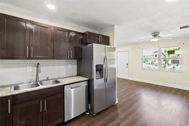 a kitchen with stainless steel appliances granite countertop a refrigerator and a sink