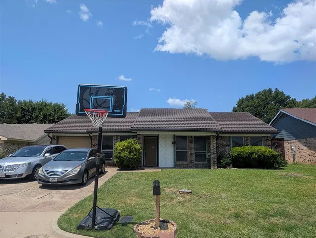 a patio with a table and chairs and potted plants