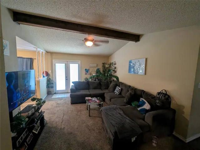a living room with furniture a window and a flat screen tv