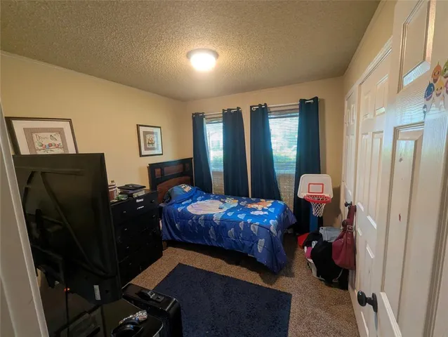 a bedroom with bed and a large mirror