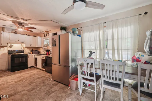 a kitchen with granite countertop a refrigerator and stainless steel appliances