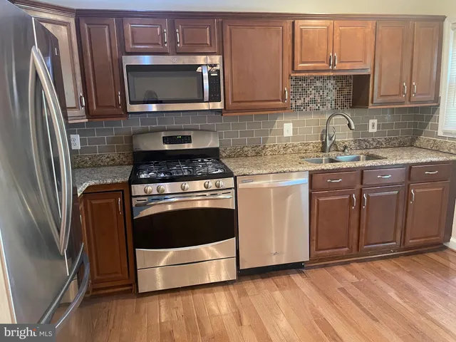 a kitchen with granite countertop a stove top oven and cabinets