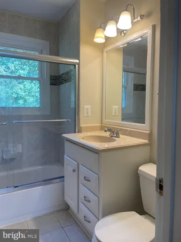a bathroom with a sink a toilet a mirror and bathtub