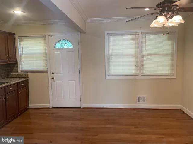 a view of an empty room with window and wooden floor