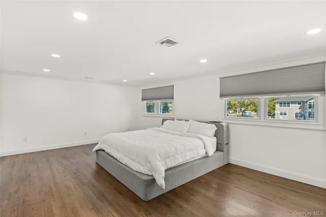 a large bedroom with a bed and a night stand