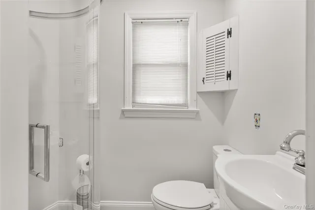 a white toilet sitting next to a bathroom sink