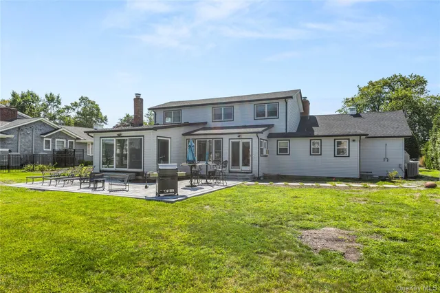 a view of a house with a big yard potted plants and large tree