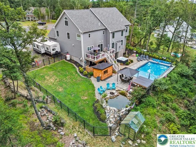 an aerial view of a house with swimming pool and outdoor seating