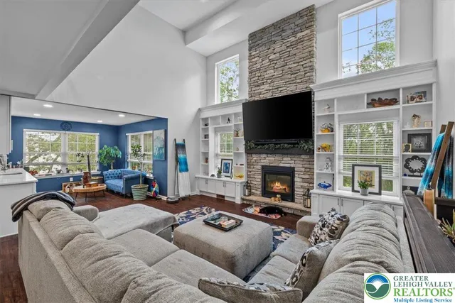 a living room with furniture fireplace and a large window