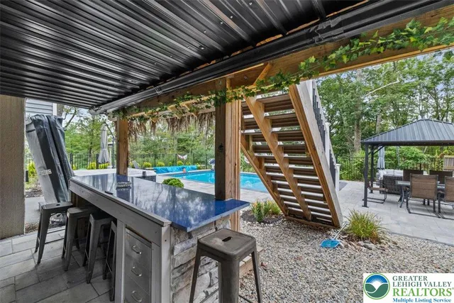 a view of swimming pool on a sunny day with lawn chairs