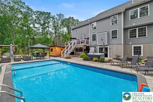 a view of a big house with a big yard and large trees