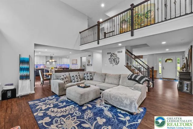 a living room with furniture and a dining table with wooden floor