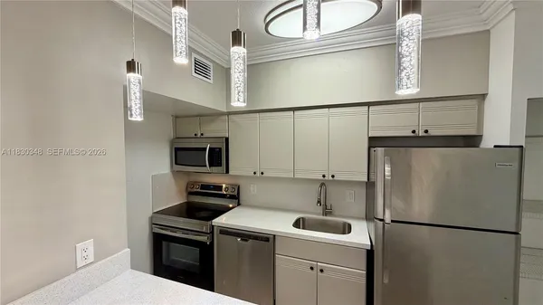 a white refrigerator freezer and a stove sitting inside of a kitchen