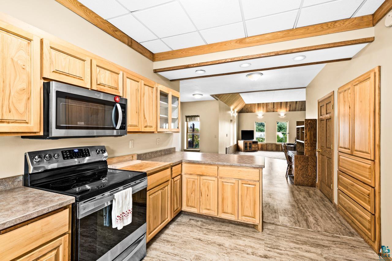 4800 Tower Road Moose Lake, MN 55767 - Photo 11 of 83 Open-concept kitchen featuring light wood cabinetry, stainless steel appliances, and durable countertop surfaces