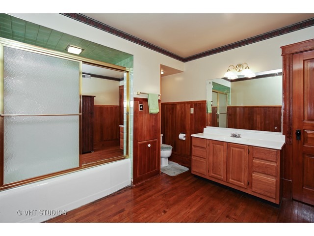 721 North Spring Street Elgin, IL 60120 - Photo 14 of 16 a bathroom with a glass door shower a sink and a mirror