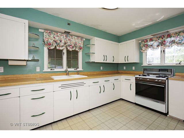721 North Spring Street Elgin, IL 60120 - Photo 10 of 16 a kitchen with granite countertop white cabinets and white appliances