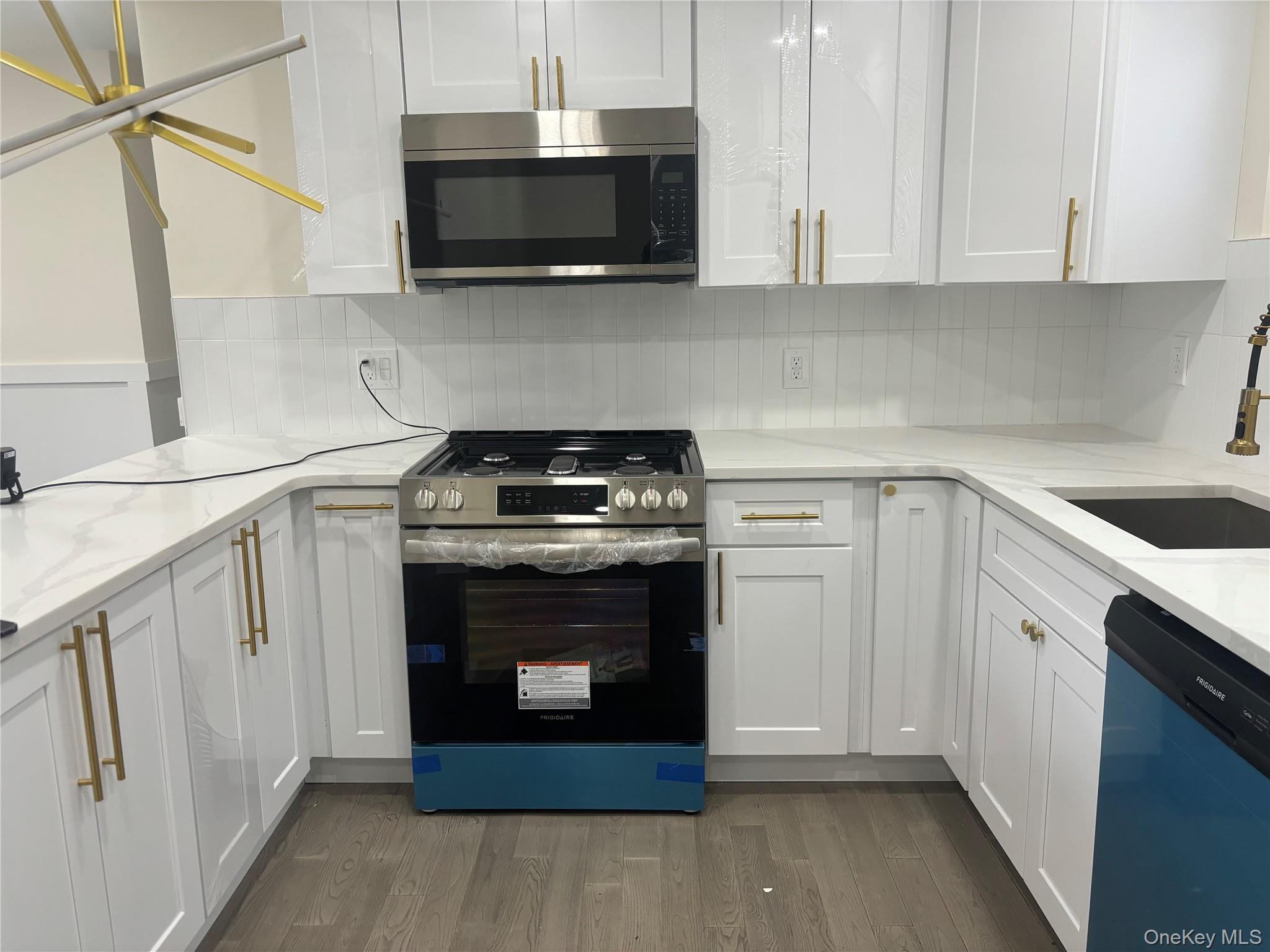 41 Tamarack Street Central Islip, NY 11722 - Photo 2 of 2 a kitchen with stainless steel appliances granite countertop a stove microwave and sink