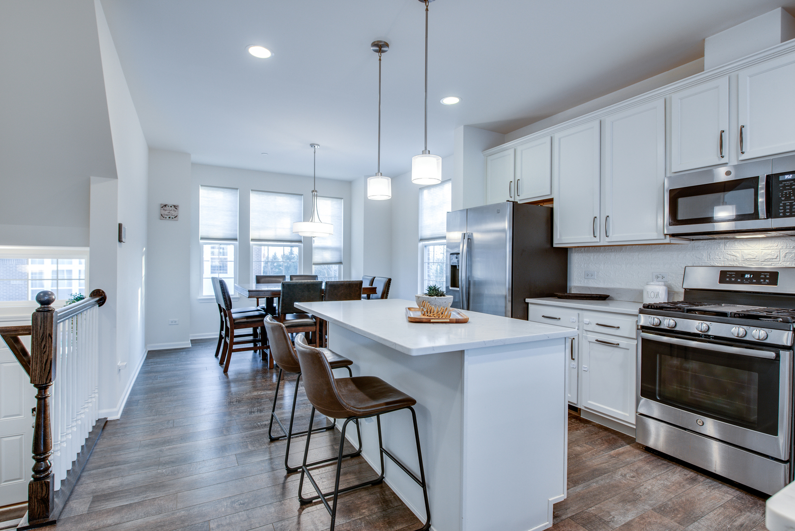 4477 Monroe Court Naperville, IL 60564 - Photo 5 of 23 a kitchen with a stove a refrigerator and a dining table with wooden floor