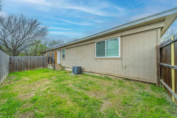 a view of an house with backyard and wooden fence