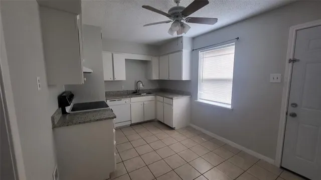 a kitchen with a sink a stove cabinets and a window