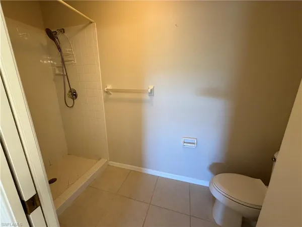 a bathroom with a granite countertop toilet and a shower