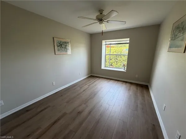 a view of an empty room window and wooden floor