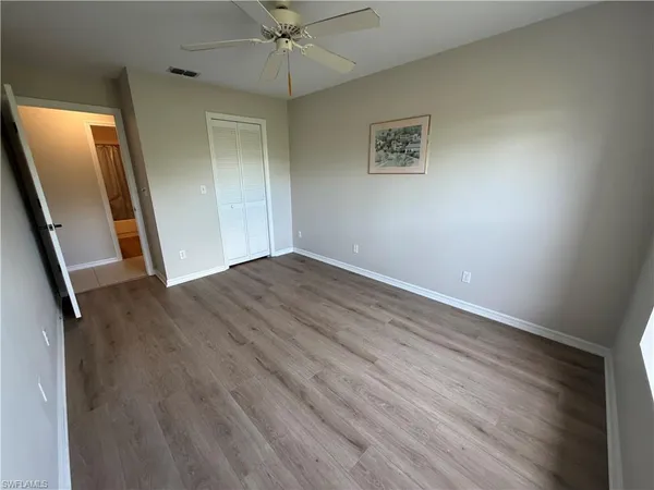 an empty room with wooden floor and sliding door