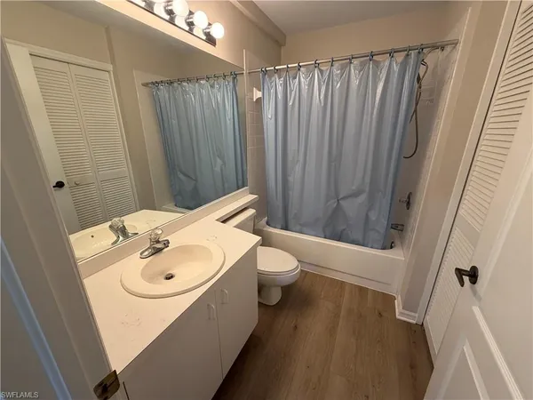 a bathroom with a sink a toilet and shower curtain