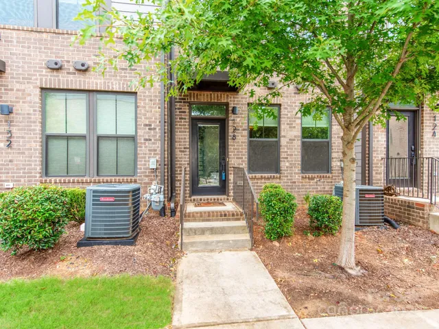 a kitchen with stainless steel appliances granite countertop a white stove top oven a sink dishwasher and a refrigerator with wooden floor