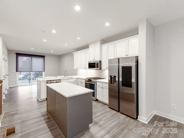 a large kitchen with a large counter top and stainless steel appliances