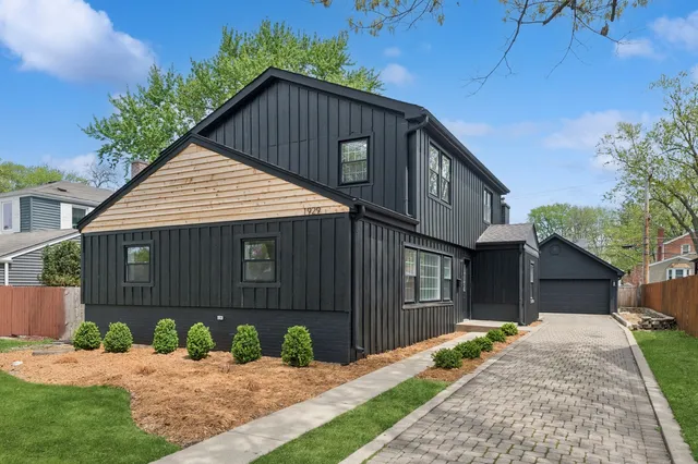 a front view of a house with a yard and potted plants