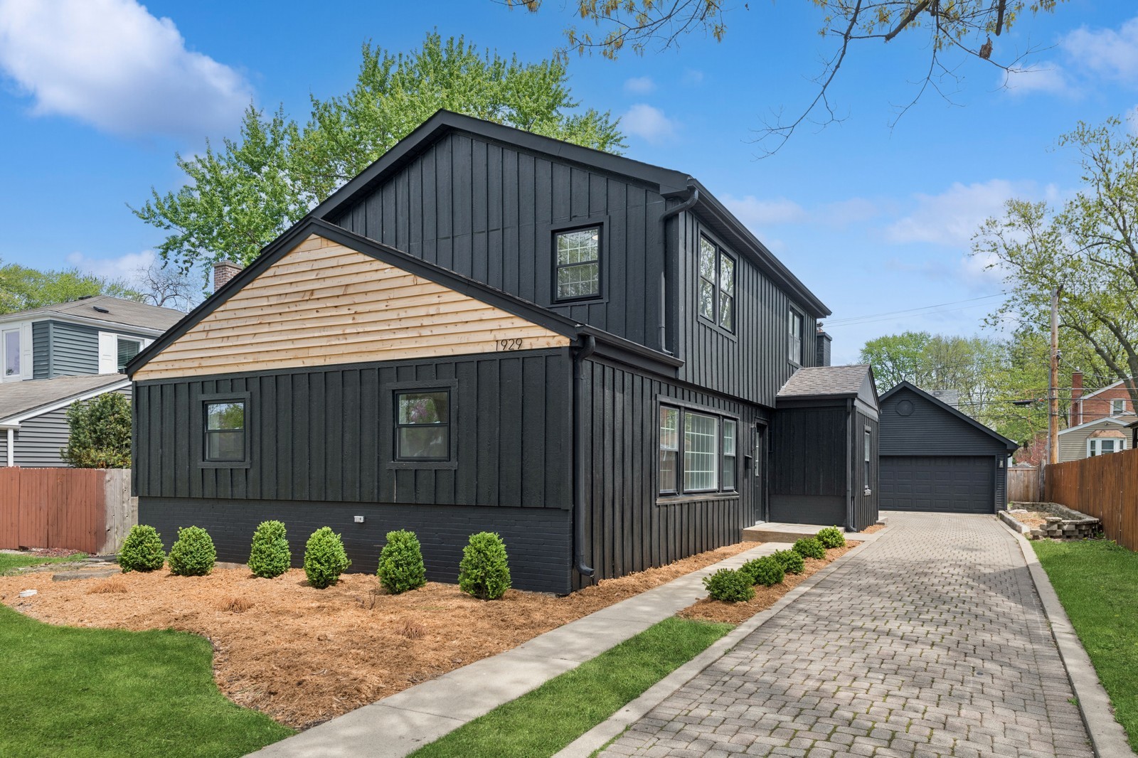 a front view of a house with a yard and potted plants