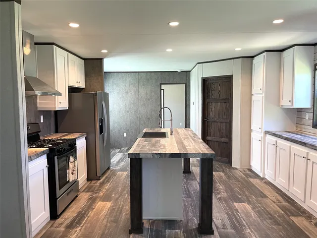a kitchen with kitchen island stainless steel appliances a sink stove and refrigerator