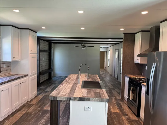 a kitchen with kitchen island a counter top space a sink stainless steel appliances and cabinets