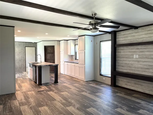 a view of a hallway with wooden floor and a living room