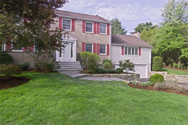 a front view of a house with a garden and plants