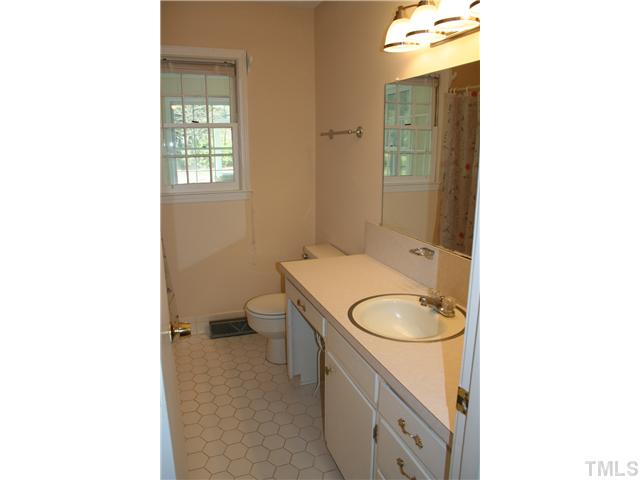 3221 Manor Ridge Drive Raleigh, NC 27603 - Photo 14 of 20 a bathroom with a toilet sink vanity and mirror