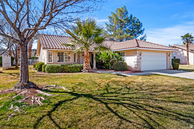 1825 West Mathis Park Place, Unit 46 St. George, UT 84770 - Photo 1 of 45 View of front of property with a front yard, an attached garage, stucco siding, and a tile roof