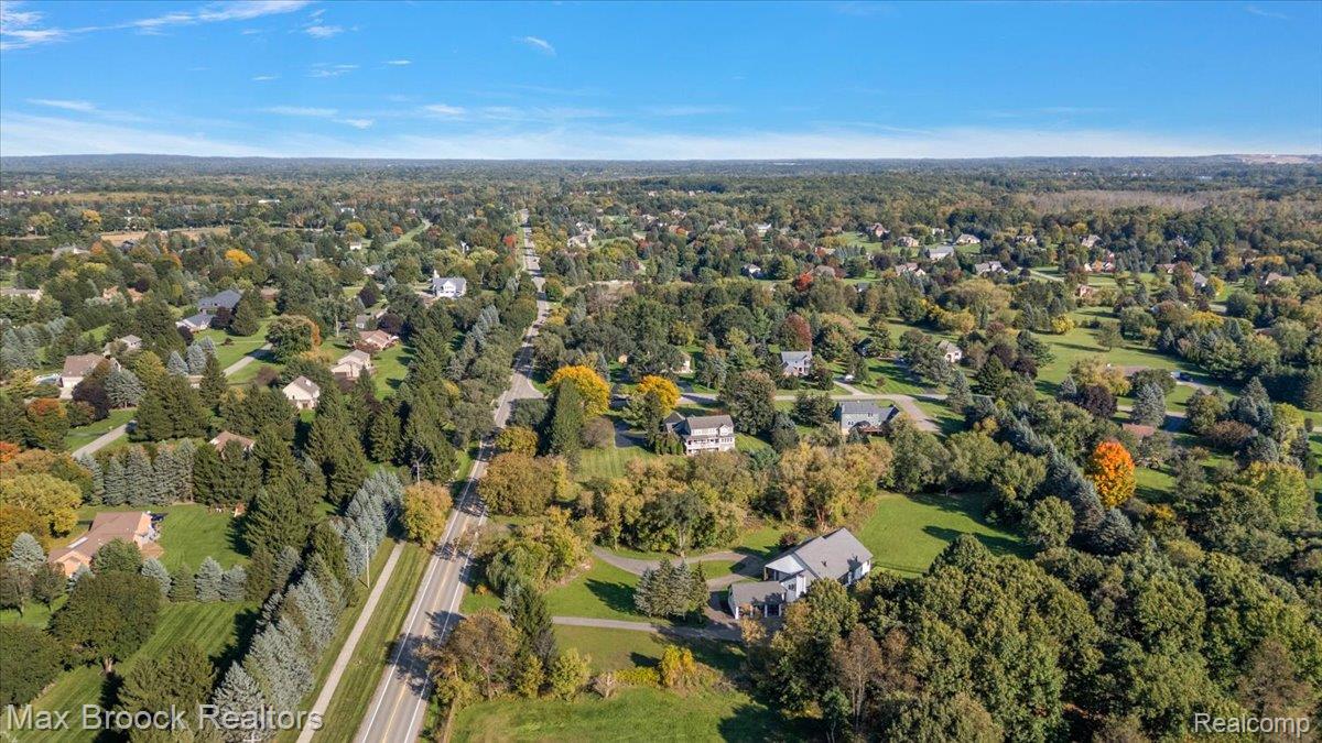4597 Clarkston Road Clarkston, MI 48348 - Photo 69 of 74 Expansive residential area featuring mature trees, a paved road, and a mix of traditional and modern homes