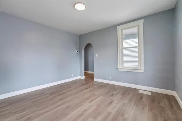 a view of a hallway with entryway and wooden floor