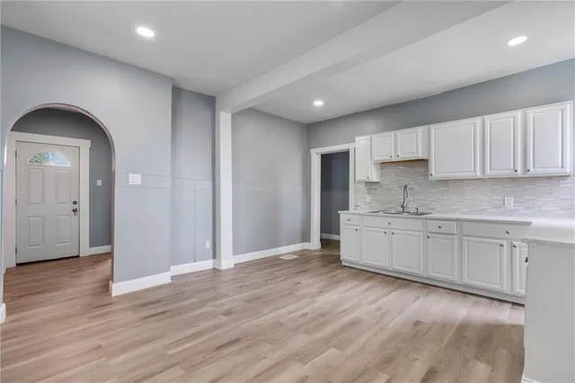 a kitchen with granite countertop white cabinets and a sink