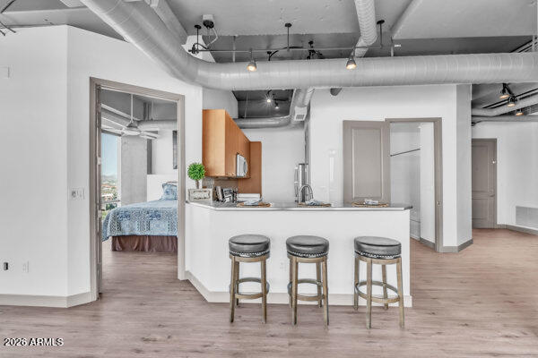 1 East Lexington Avenue, Unit 809 Phoenix, AZ 85012 - Photo 8 of 44 a kitchen with kitchen island granite countertop a table and chairs in it