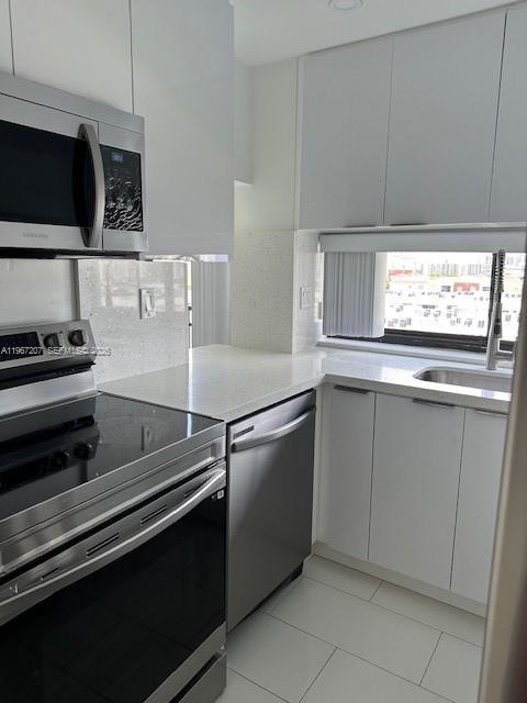 17021 North Bay Road, Unit 904 Sunny Isles Beach, FL 33160 - Photo 9 of 18 a kitchen with cabinets and stainless steel appliances