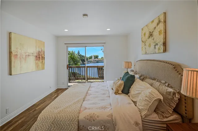 a view of a hallway with wooden floor and a bathroom