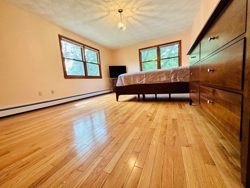 143 Reed Street Lexington, MA 02421 - Photo 15 of 19 a room with a bed and a window with wooden floor